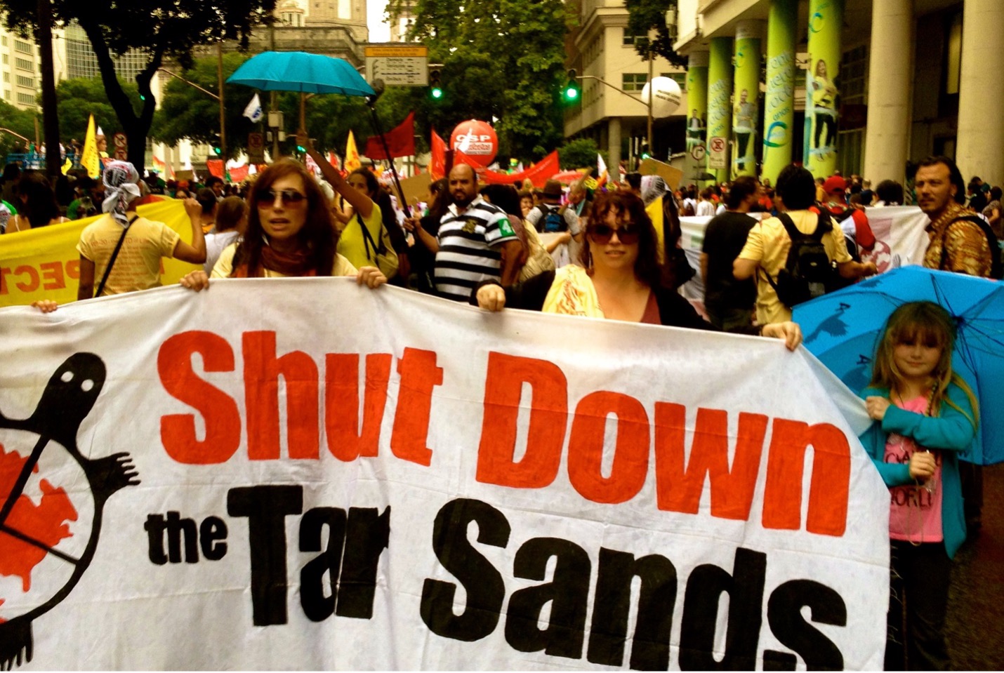 a banner at a rally at a UN climate convention that says stop the tarsands